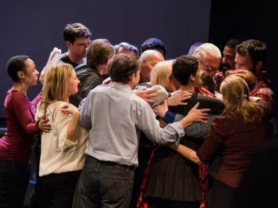 Standing group of people huddled in a group hug